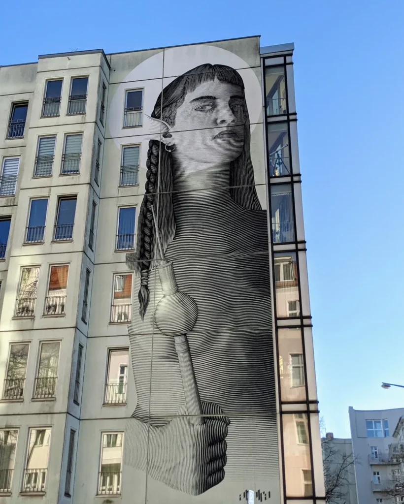 Wandbild von Alfalfa (Nicolás Sánchez) an der Mommsenstraße in Berlin-Charlottenburg: Göttin mit Zopf als feine Linienzeichnung, in der Faust der Fernsehturm