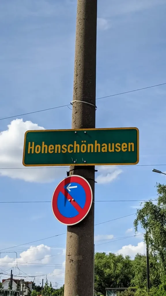 Ortsschild Hohenschönhausen mit Parkverbotsschild am Straßenrand im Südosten von Alt-Hohenschönhausen