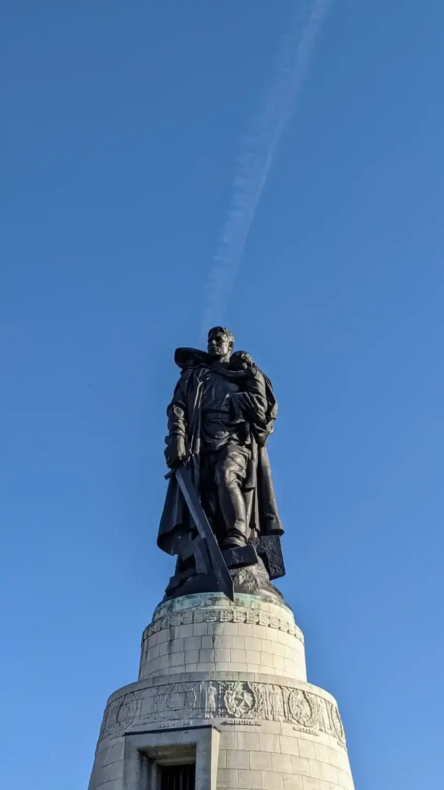 Bronzesoldat auf dem Mausoleum des Sowjetischen Ehrenmals in Alt-Treptow vor blauem Himmel