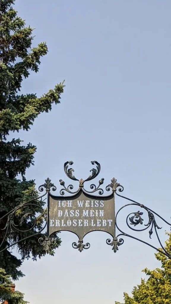 Schmiedeeiserner Torbogen mit Inschrift am Evangelischen Friedhof Am Alten Friedhof in Altglienicke