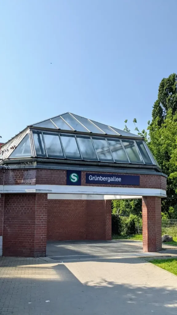 Eingang des S-Bahnhofs Grünbergallee in Altglienicke mit gläsernem Vordach