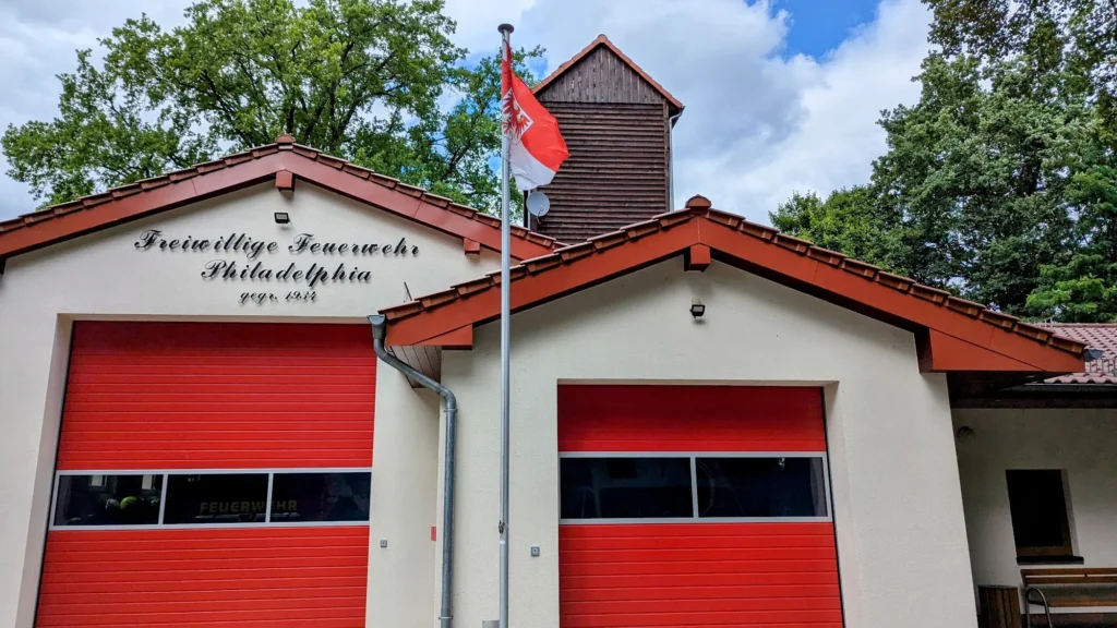 Gerätehaus der Freiwilligen Feuerwehr Philadelphia mit roten Toren und hölzernem Schlauchturm