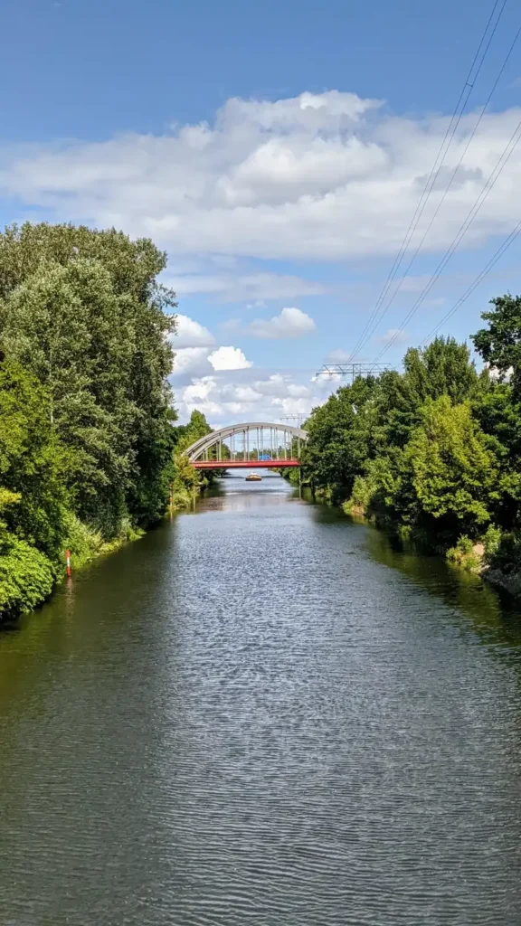 Britzer Verbindungskanal in Baumschulenweg mit einer roten Brücke und grünen Ufern