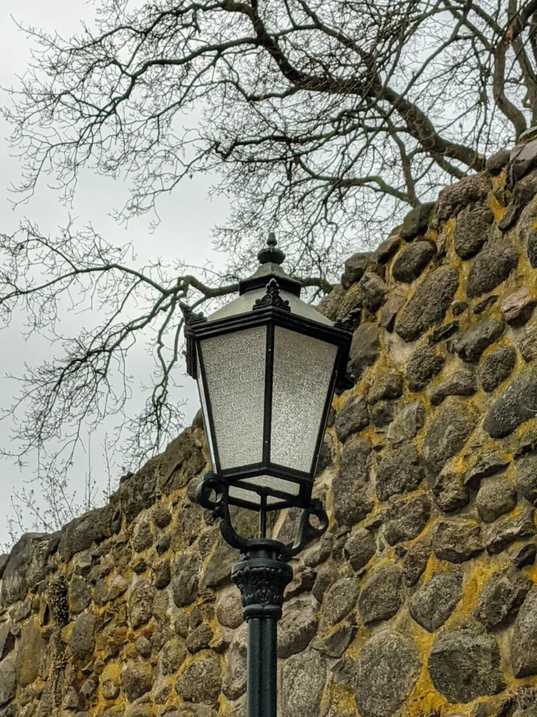 Stadtmauer aus Feldsteinen mit einer Laterne in Bernau