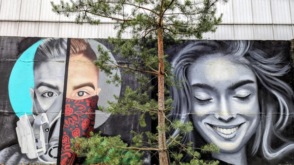 Graffiti-Wandbild mit Gesichtern an einer Mauer