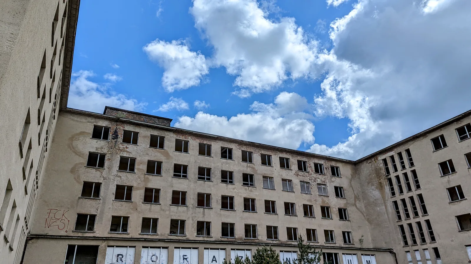 Unsanierter Block in Prora mit verwitterter Fassade und Buchstaben in den Fenstern