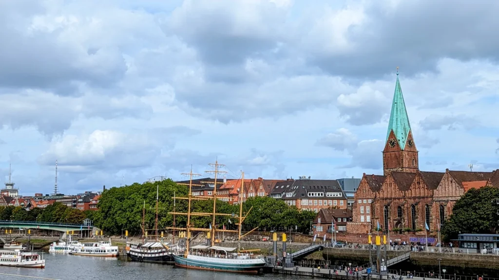 Blick über die Weser mit Schiffen und einem Kirchturm in Bremen