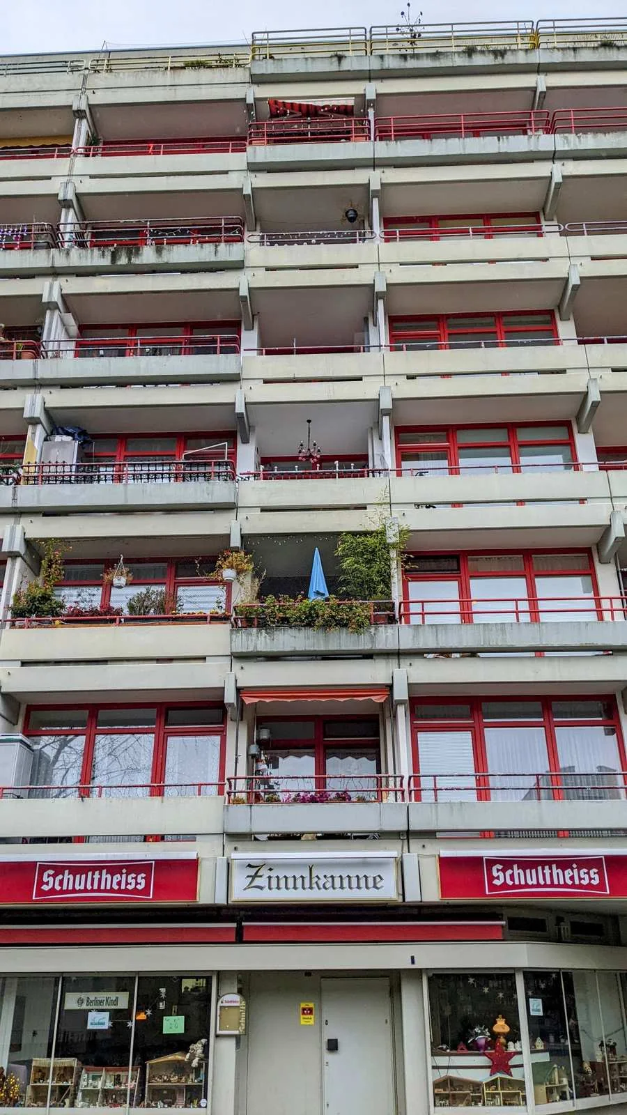 Fassade eines Wohnhochhauses mit Balkonen und roten Fensterrahmen im Ortsteil Buckow