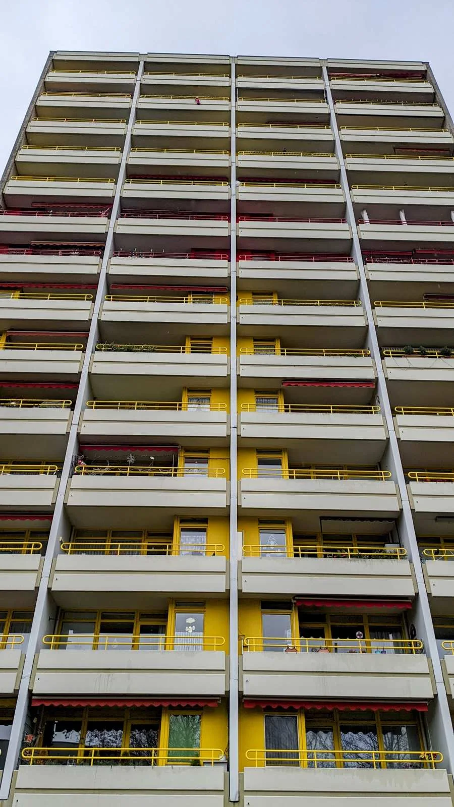 Hohe Balkonfassade eines Wohnhochhauses mit gelben Geländern im Ortsteil Buckow