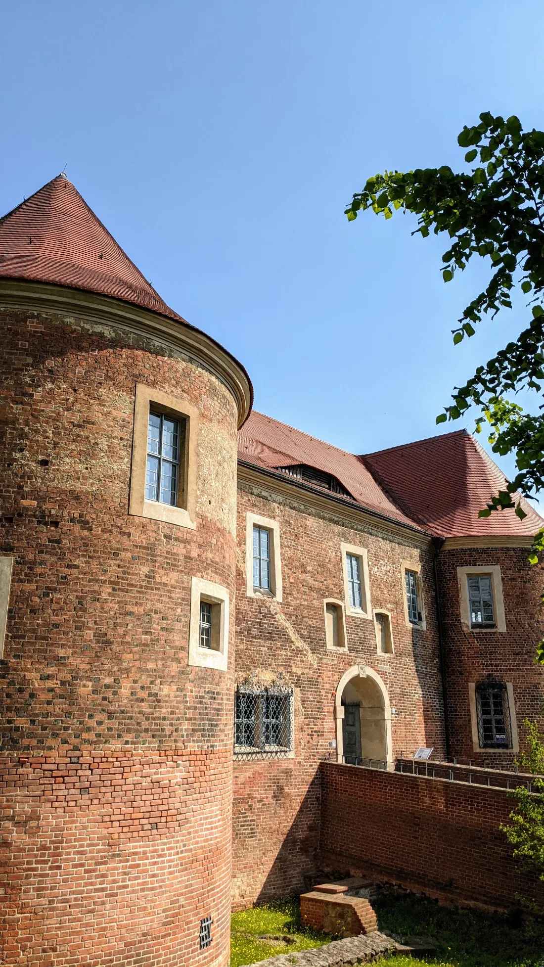 Runder Turm mit rotem Dach an der Burg Eisenhardt in Bad Belzig