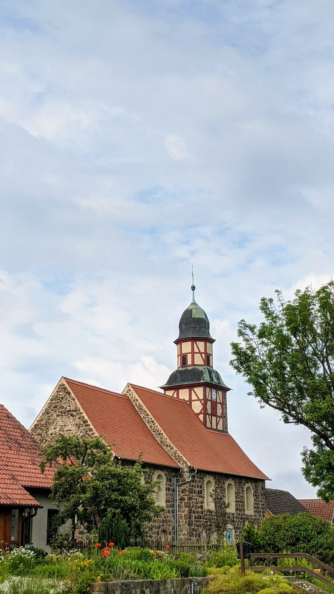 Feldsteinkirche mit rotem Dach und Dachreiter in Raben