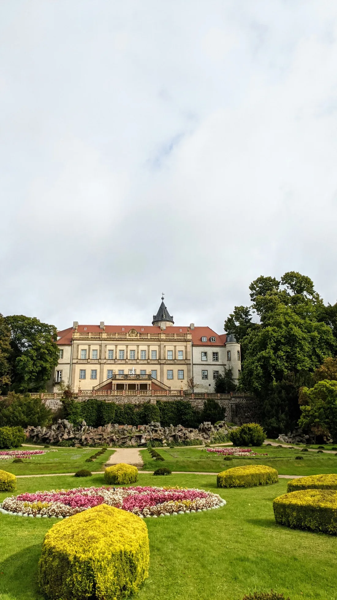 Schloss Wiesenburg hinter einem Blumenrondell im Park