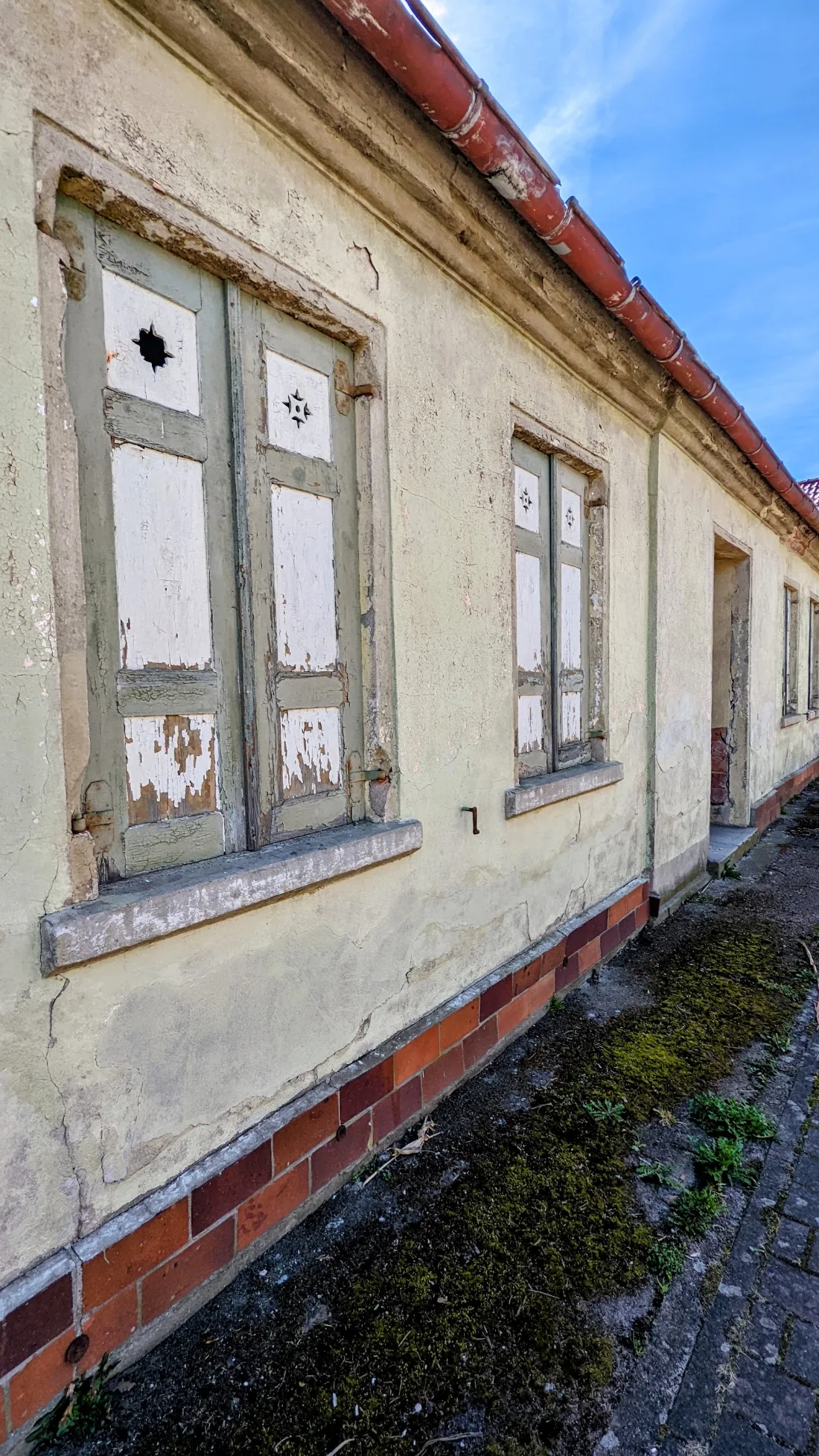 Verlassenes gelbes Haus mit verwitterten Fensterläden bei Köpernitz