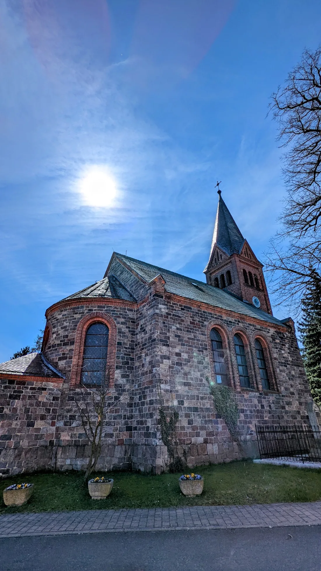 Feldsteinkirche in Köpernitz vor blauem Himmel mit Sonne