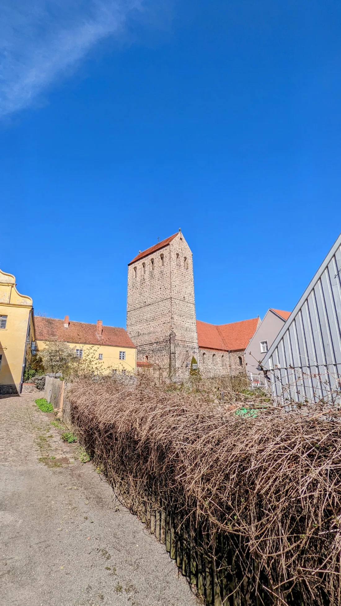 Feldsteinturm der Heilig-Kreuz-Kirche zwischen Häusern in Ziesar