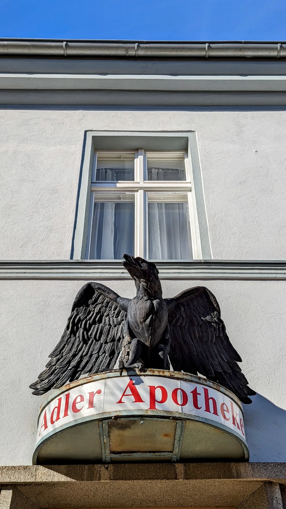 Metalladler über dem Schild der Adler Apotheke in Ziesar