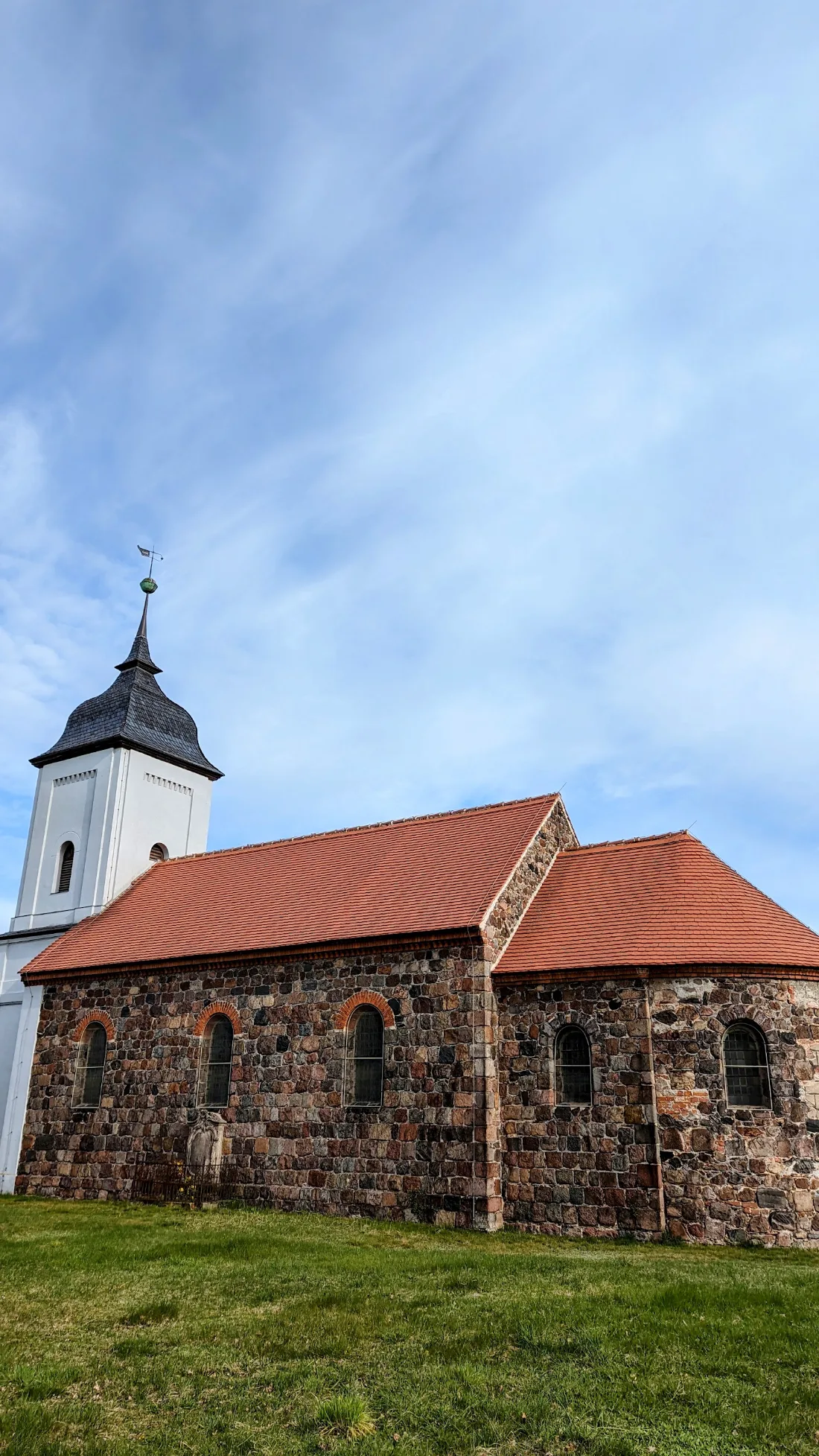 Feldsteinkirche mit weißem Turm in Bücknitz