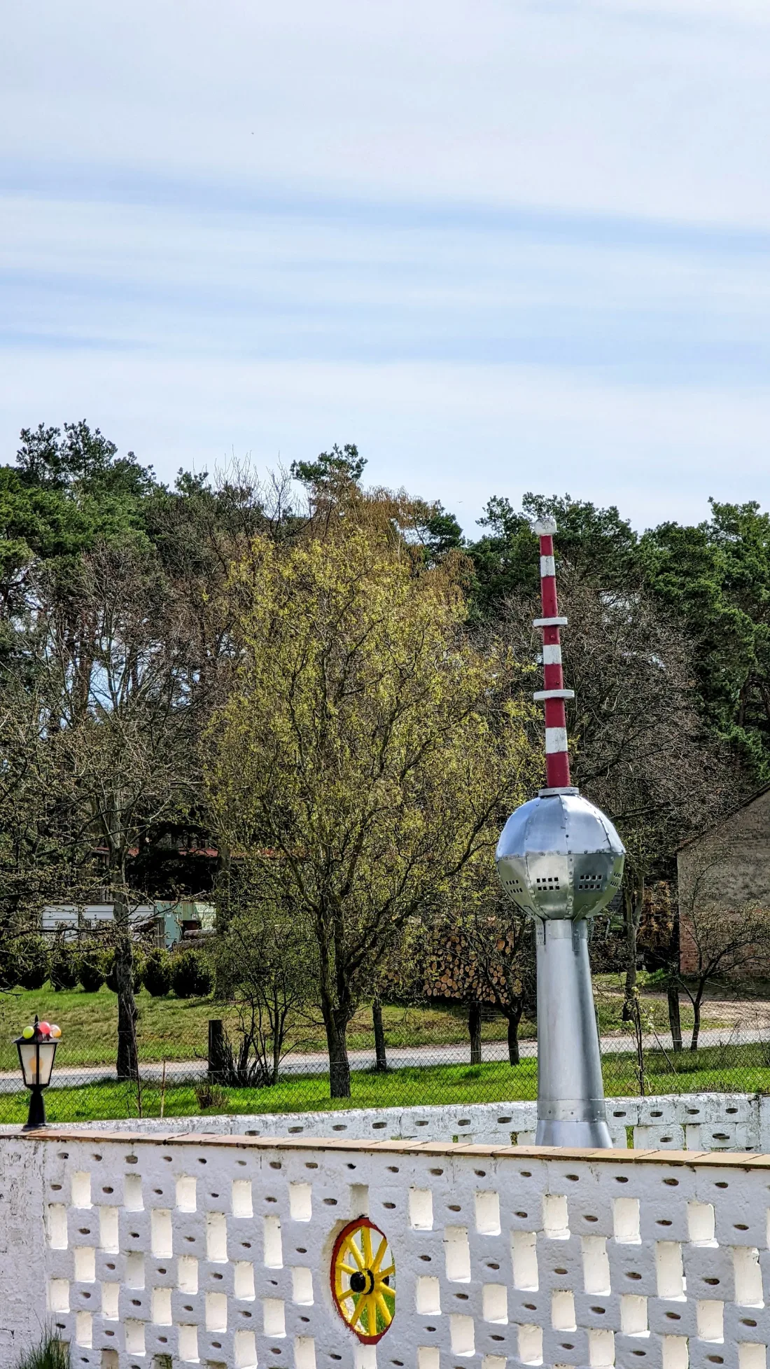 Kleiner Nachbau des Berliner Fernsehturms hinter einer Ziermauer