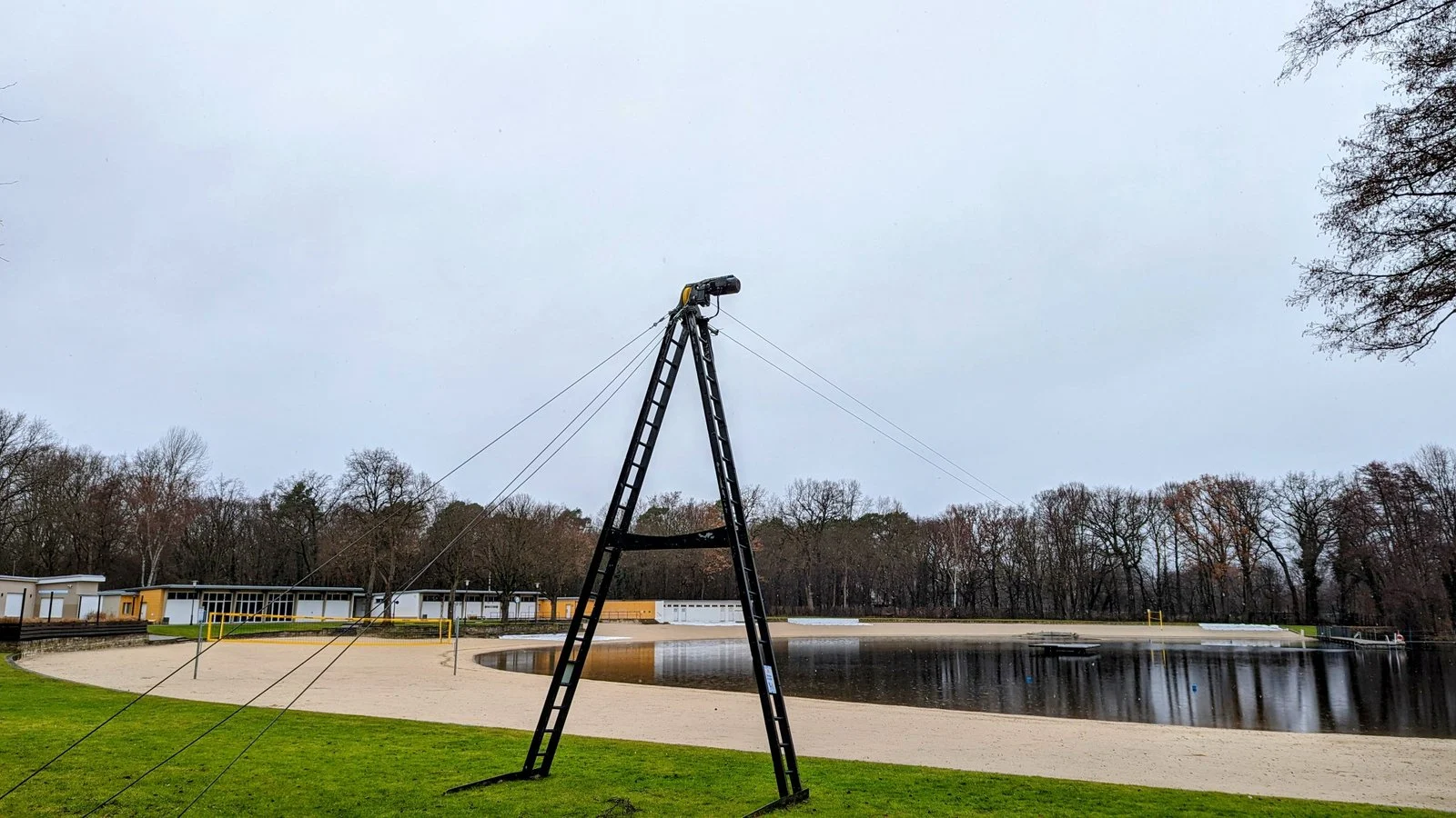 Sandstrand am Jungfernheideteich im Volkspark Jungfernheide, davor ein schwarzes A-förmiges Gerüst