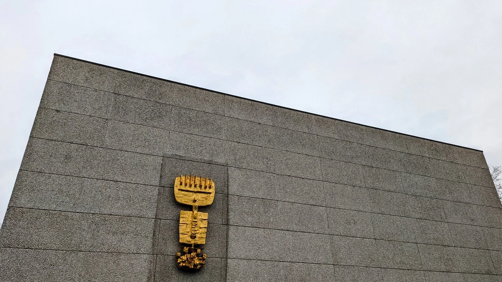 Vergoldete Plastik an der Betonfassade der Gedenkkirche Maria Regina Martyrum am Heckerdamm
