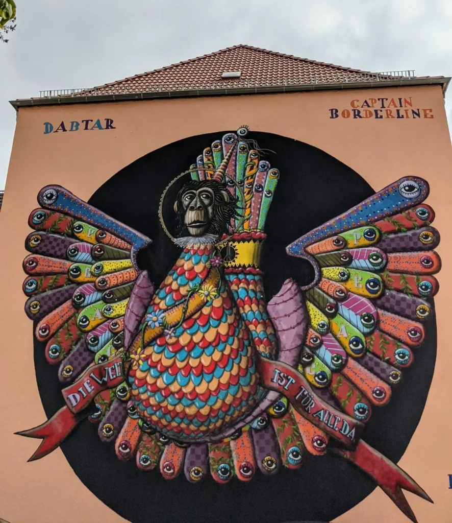 Wandbild von Dabtar und Captain Borderline in Kleinwittenberg, Lutherstadt Wittenberg: buntes Mischwesen mit Affenkopf und Flügeln voller Augen