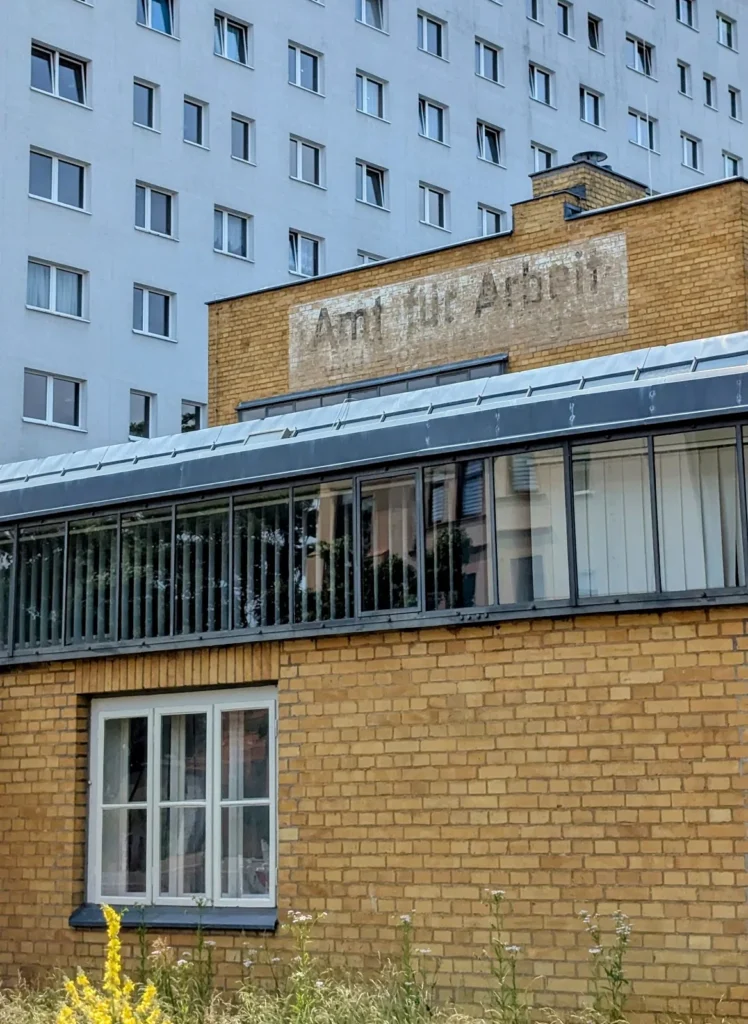 Gelbe Backsteinfassade des ehemaligen Arbeitsamts in Dessau mit dem Schriftzug Amt für Arbeit