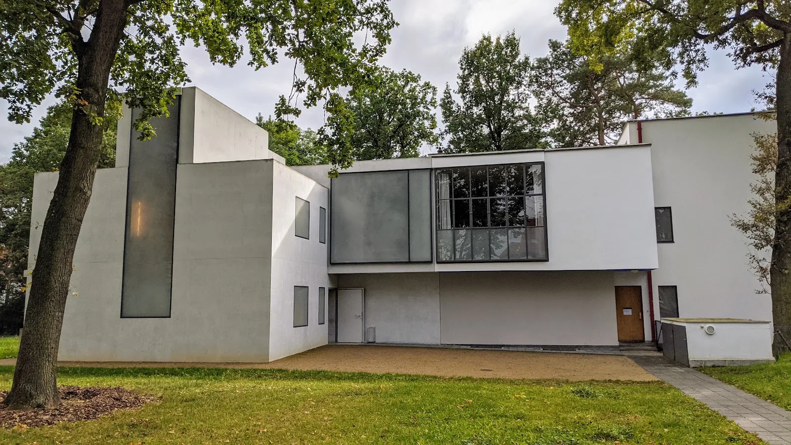 Weißer kubischer Bau an der Ebertallee in Dessau mit großer dunkler Glasfläche