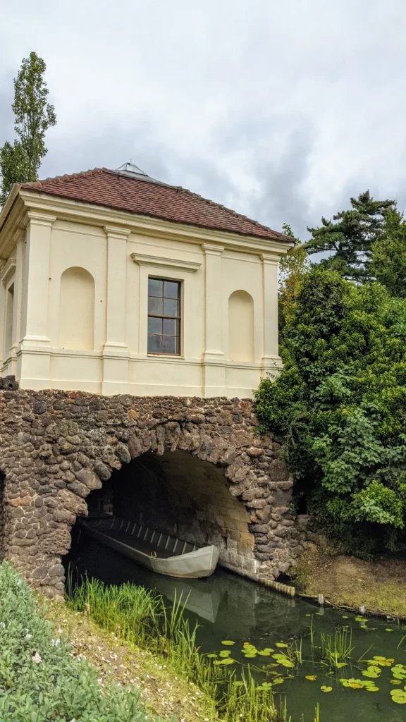 Kleiner Pavillon über einer Grotte am Wasser im Wörlitzer Park, darin ein Kahn