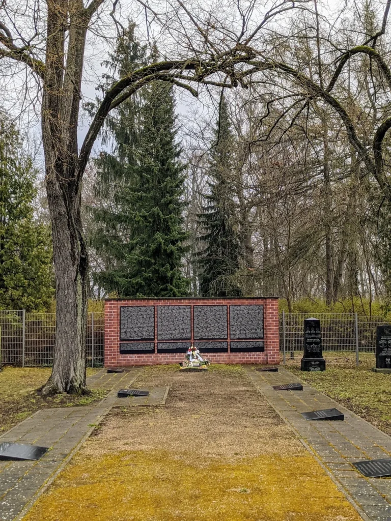 Gedenkwand mit schwarzen Namenstafeln in einer Backsteinmauer auf dem Sowjetischen Garnisonsfriedhof in Eberswalde