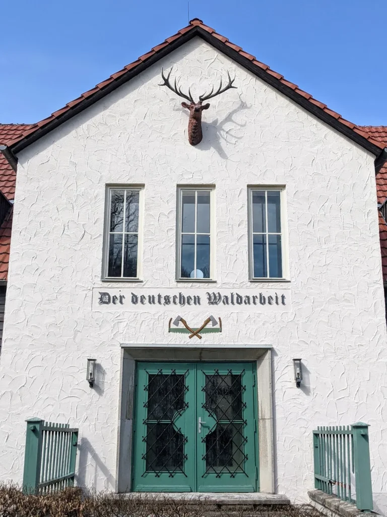 Giebel des Hauses mit der Inschrift „Der deutschen Waldarbeit“ und gekreuzten Äxten über der Tür in Eberswalde