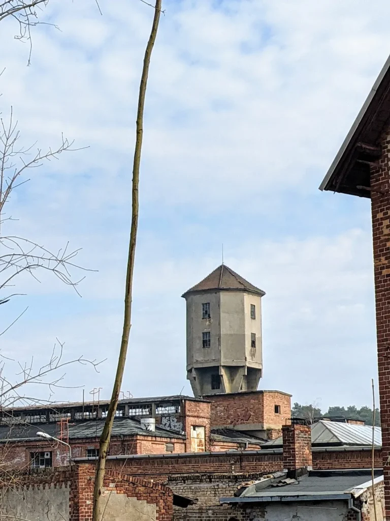 Turm eines Wasserturms über den Backsteinbauten eines Industriegeländes in Eberswalde