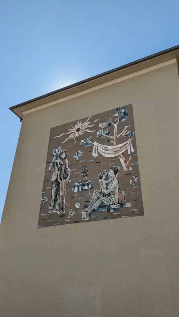 Mosaik Familienfreude an einem Giebel im Wohnkomplex I: Mutter mit Kind, sitzender Vater, Sonne und Wäscheleine