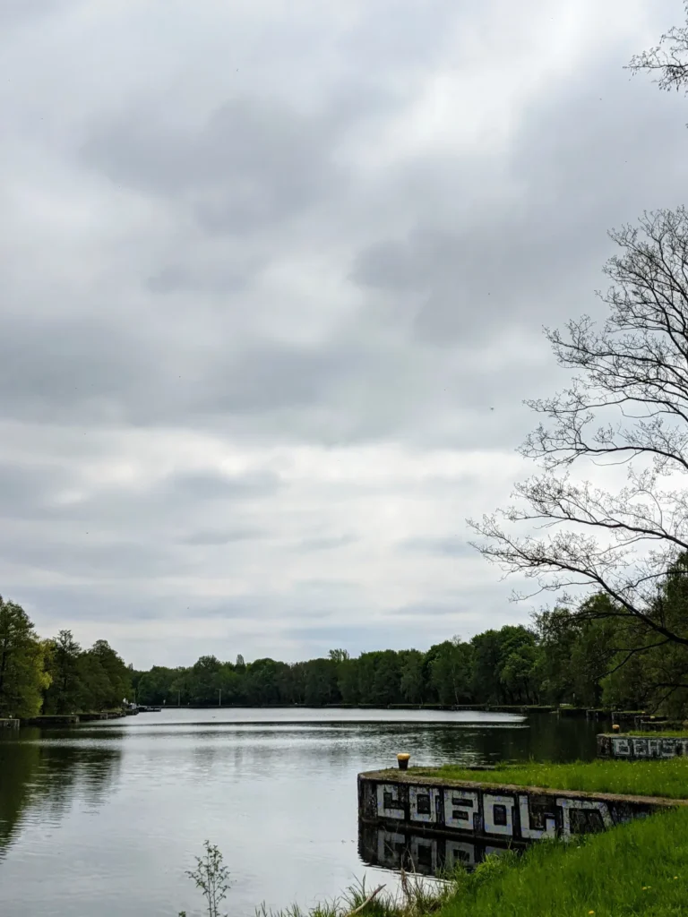 Breites Wasser des Oder-Spree-Kanals an der Insel in Eisenhüttenstadt, am Ufer ein besprühter Betonklotz