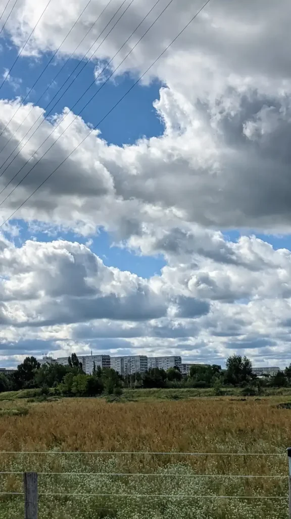 Weite Feldflur im Norden von Falkenberg, am Horizont mehrere Plattenbauten am Stadtrand