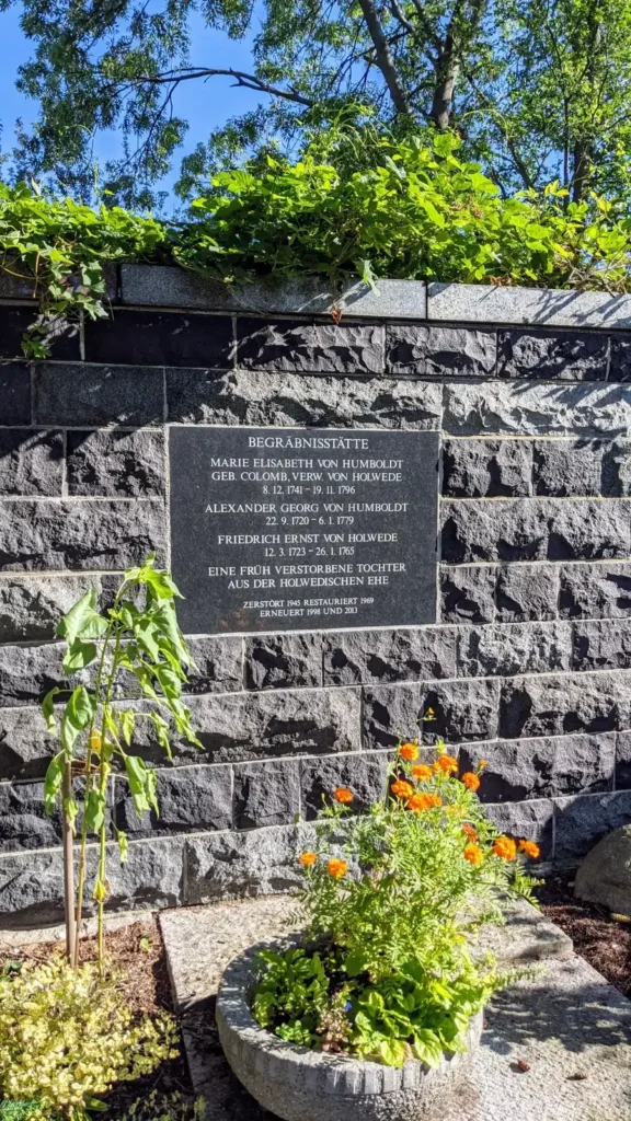 Gedenkmauer mit Tafel und abgelegten Blumen auf dem Friedhof an der Dorfstraße in Falkenberg