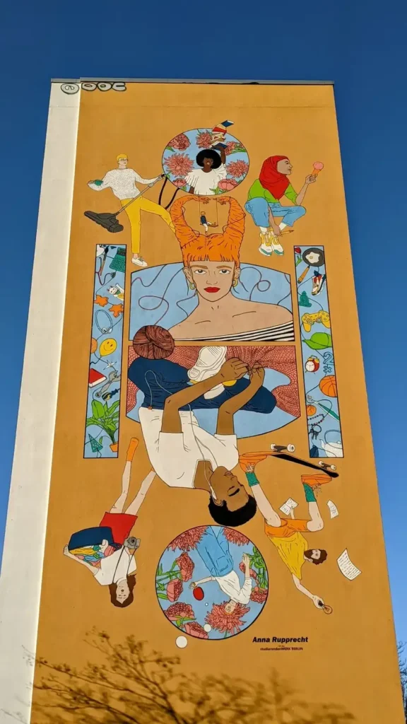 Hochhausgiebel im Süden von Fennpfuhl mit buntem Wandbild auf orangem Grund