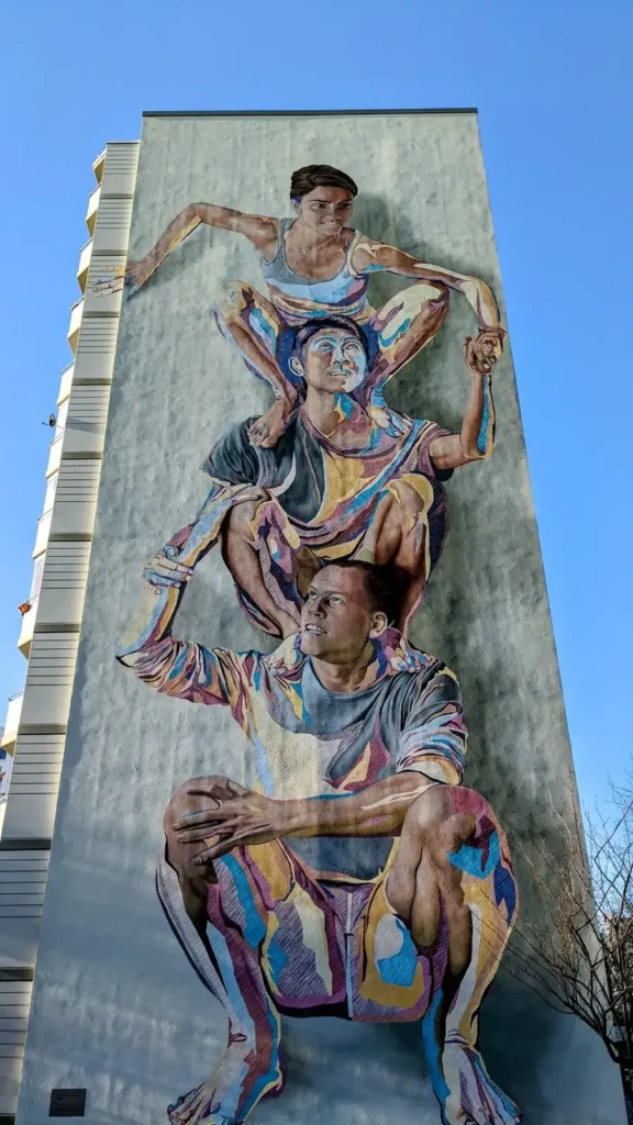 Großes Wandbild "Totem" von JBAK mit übereinander gestapelten Figuren am Hochhausgiebel an der Landsberger Allee