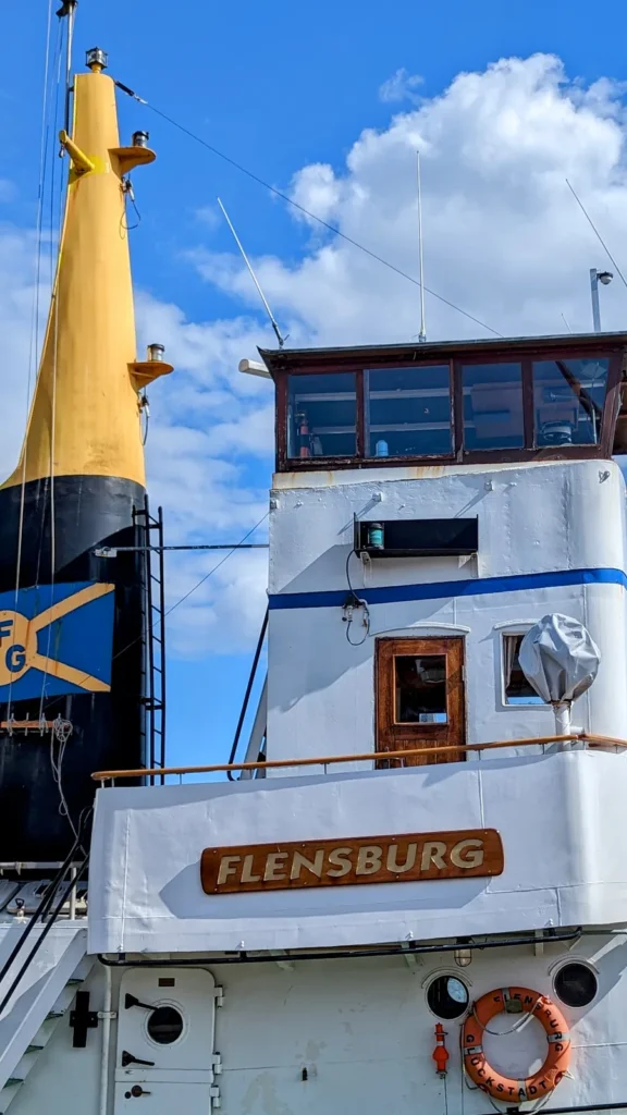Bug eines Hafenschiffs mit dem Schriftzug Flensburg an der Schiffbrücke