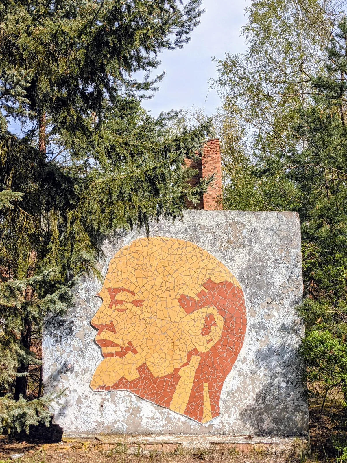 Lenin-Porträt im Profil aus Keramikscherben an einer freistehenden Betonwand im Wald bei Brand