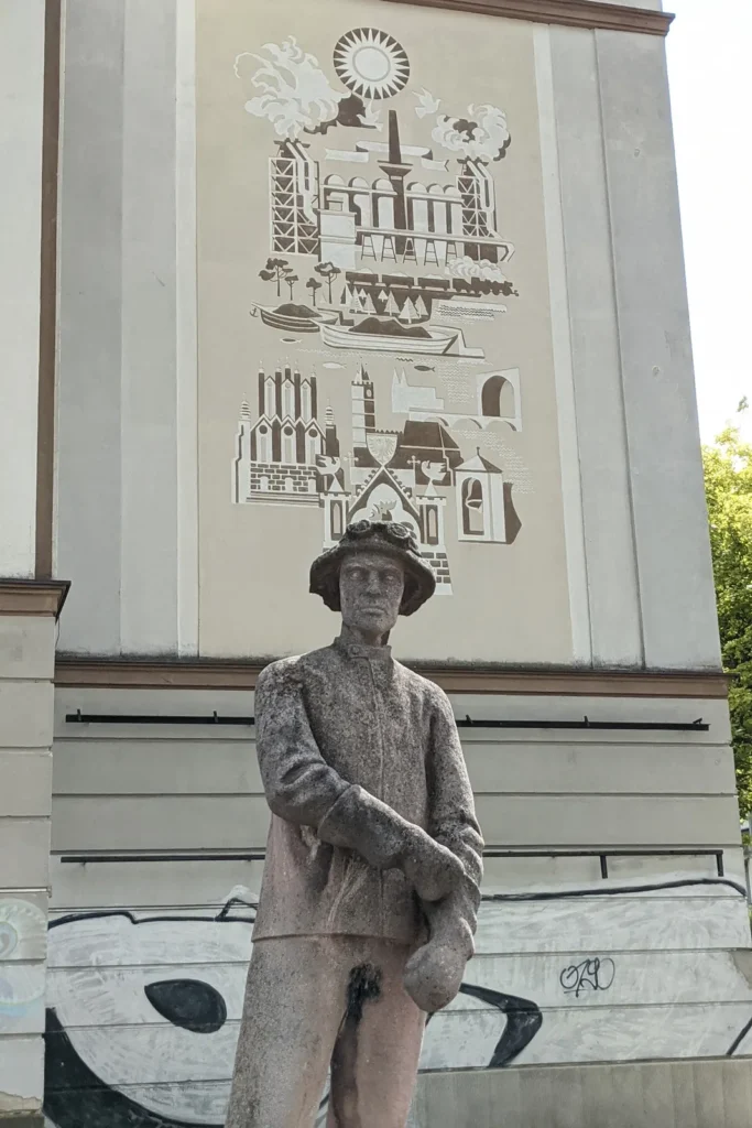 Betonfigur Stahlwerker vor einem Wandbild am ehemaligen Lichtspieltheater in Frankfurt (Oder)