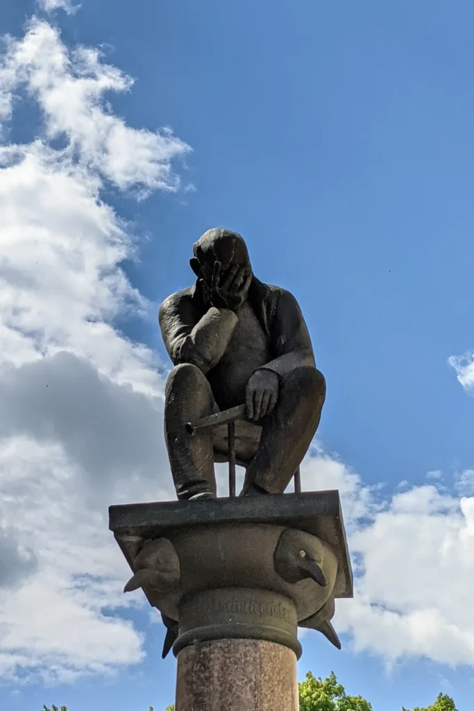 Bronzefigur „Sinnender auf Kapitell“ von Eckhard Herrmann in der Großen Scharrnstraße in Frankfurt (Oder)