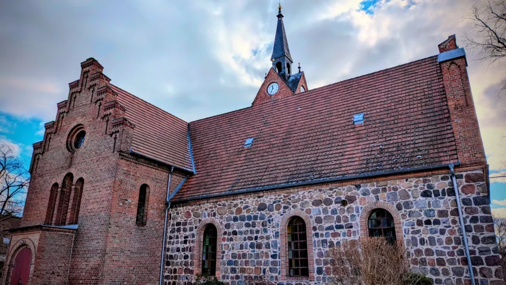 Dorfkirche Französisch Buchholz mit Feldsteinwand, Backsteinanbau mit Staffelgiebel und Dachreiter mit Uhr