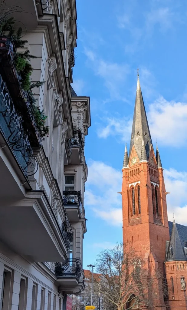 Turm der Kirche Zum Guten Hirten am Friedrich-Wilhelm-Platz in Friedenau über Gründerzeithäusern
