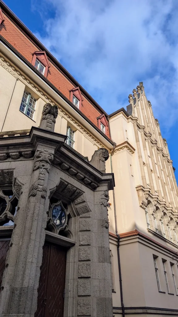 Steinportal mit Bauplastik und Staffelgiebel an einem Schulbau im Südwesten von Friedenau