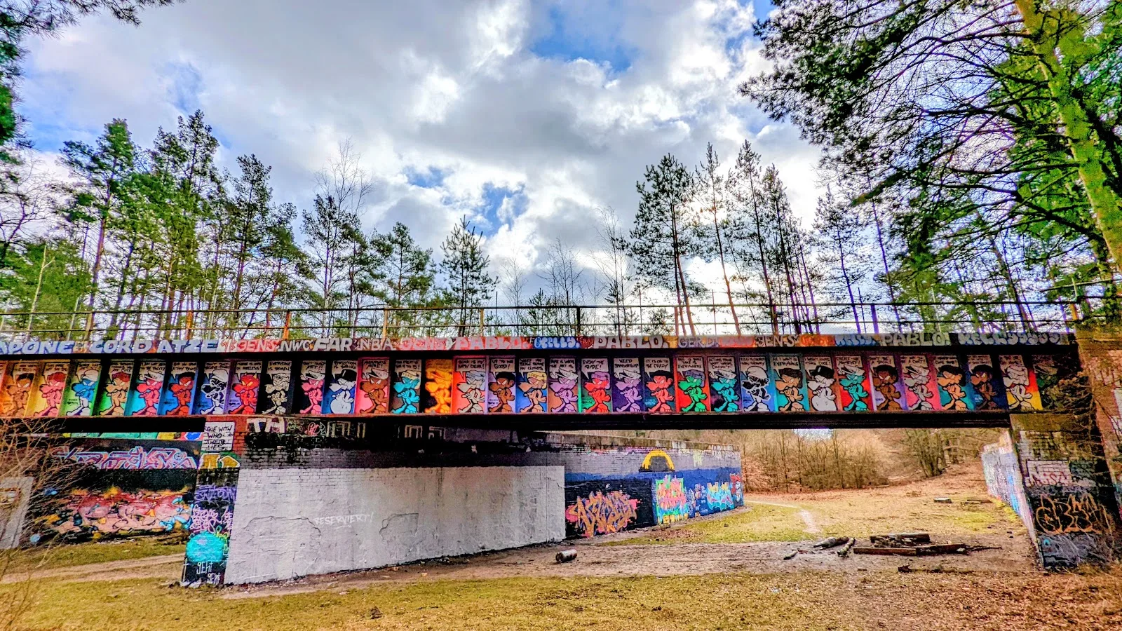 Stahlbrücke mit bunten Graffiti im Wald bei Dreilinden
