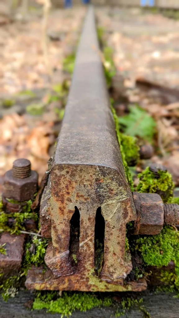 Nahaufnahme einer alten Schiene mit Befestigung an der früheren Friedhofsbahn bei Wannsee