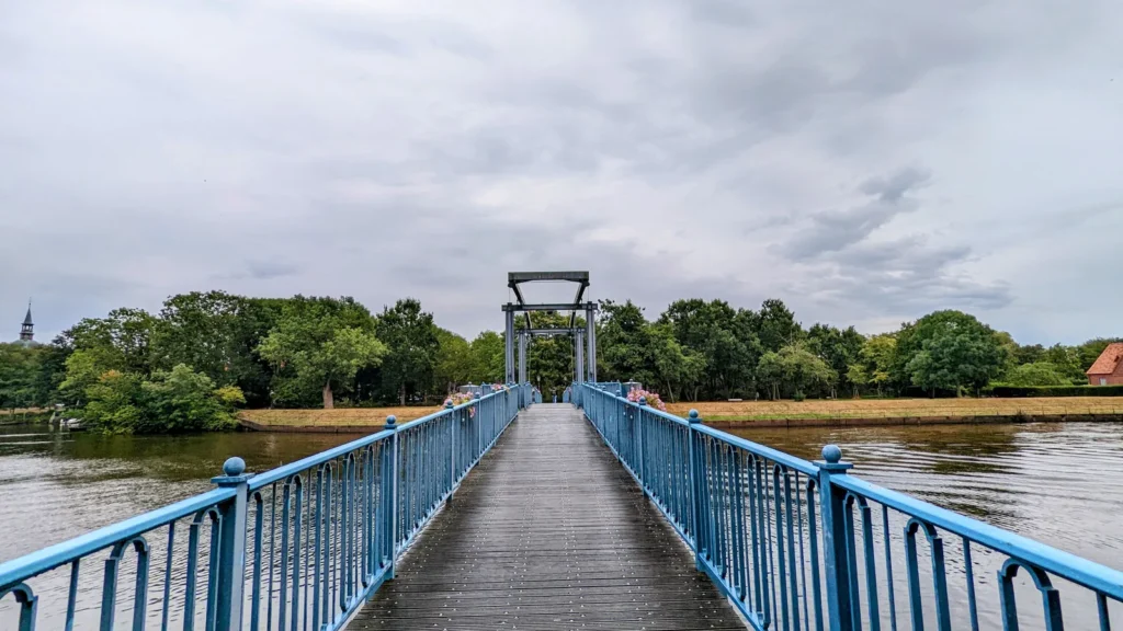 Blaue Fußgängerbrücke mit Hubturm über das Wasser in Friedrichstadt