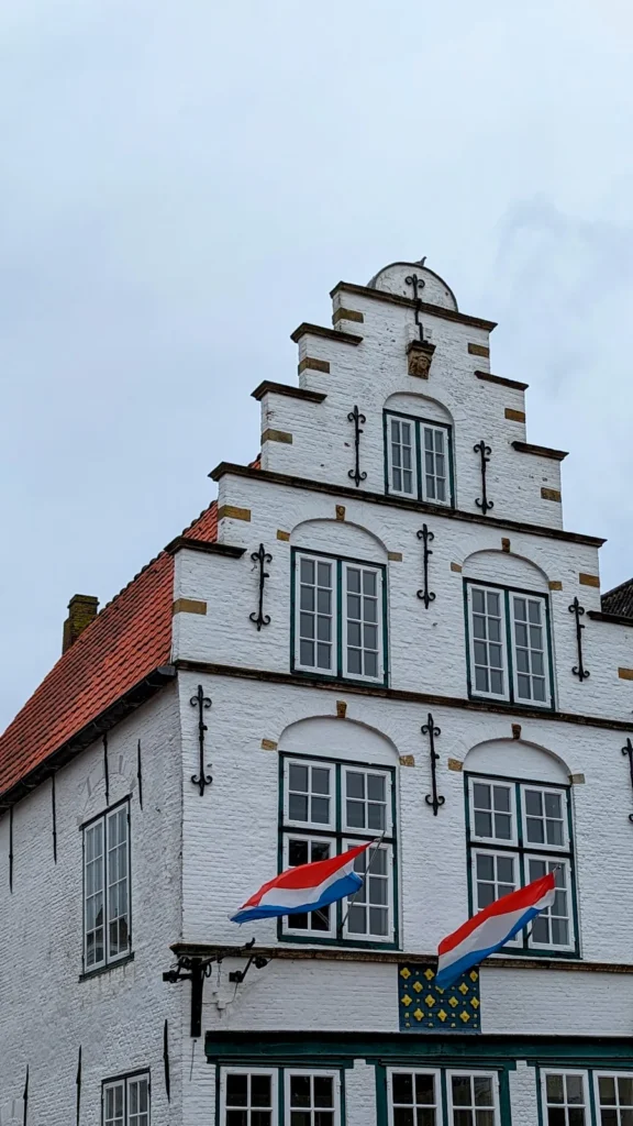 Weißer Treppengiebel mit niederländischen Flaggen in der Altstadt von Friedrichstadt