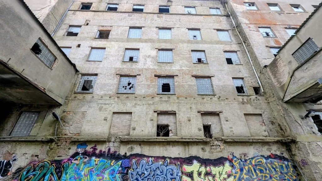 Hohe Fensterfassade der ehemaligen Behrnschen Mühle in Fürstenberg/Havel mit Graffiti am Sockel