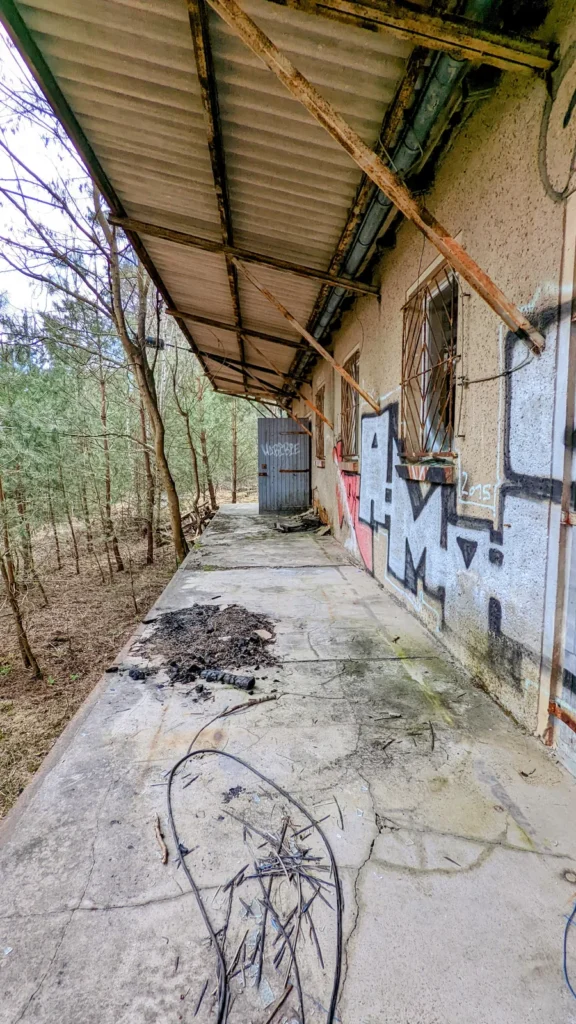 Überdachter Gang entlang eines Gebäudes mit Graffiti an der Wand